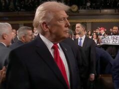 Al Green tiene un cartello con la scritta “I neri non sono scimmie” dietro Donald Trump alla cerimonia sullo Stato dell’Unione